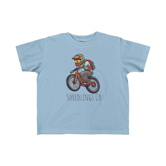 Light blue Shredlings kids tee with an illustrated mountain biker